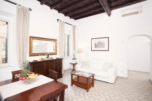 a living room with a white couch and a table at Tritone 91 Apartments in Rome