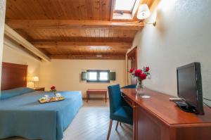 Zimmer mit einem Bett und einem Schreibtisch mit einem TV in der Unterkunft Park Hotel Villa Americana in Rodi Garganico