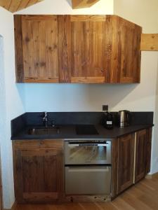 een keuken met houten kasten, een fornuis en een wastafel bij Studio 166 Le Bristol Villars in Villars-sur-Ollon