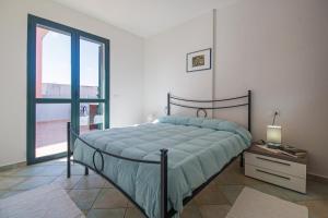 sypialnia z łóżkiem i dużym oknem w obiekcie Residenza Maria Antonia - Private Apartment w mieście Orosei