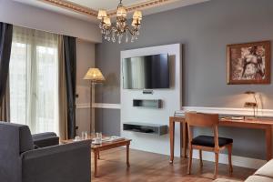 a living room with a table and a tv on the wall at Ava Hotel and Suites in Athens