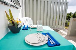a table with plates and glasses on a blue table at Bellevue Suites in Buckleys