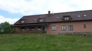 ein großes Haus auf einem Hügel mit einem Zaun in der Unterkunft Penzion Slávka in Třemošnice