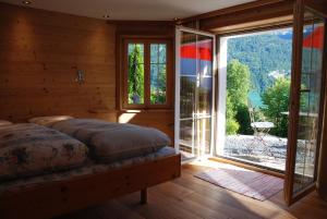 ein Schlafzimmer mit einem Bett und einem großen Fenster in der Unterkunft Jobin Brienz in Brienz