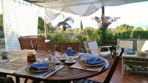 a wooden table with blue napkins and dishes on it at Arcamyrtus in Alghero +37 photos