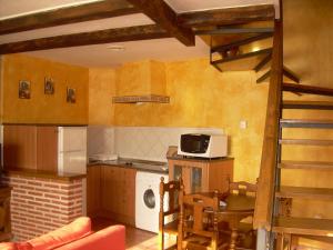 a kitchen with a stove and a microwave at El Cerrillo 1 in San Martín del Pimpollar