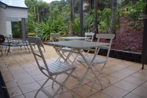 a dining room table with chairs and a patio at Tiarri Terrigal in Terrigal