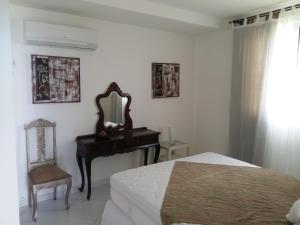 a bedroom with a bed and a mirror and a chair at Habana Beach Flat in Natal
