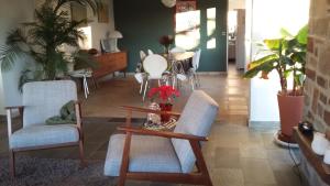 ein Wohnzimmer mit zwei Stühlen und einem Tisch in der Unterkunft Maison Vintage Ardenne in Awenne