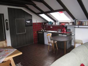 シュヴァンガウにあるHaus Forggenseeのテーブル付きのキッチン、赤いタイルのキッチンが備わります。