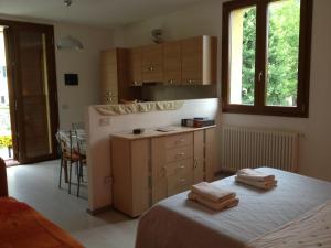 una cucina con letto e bancone con asciugamani di Casa Pini a Griante Cadenabbia