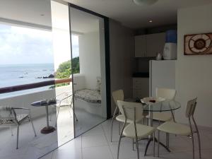 a kitchen and dining room with a view of the ocean at Habana Beach Flat in Natal
