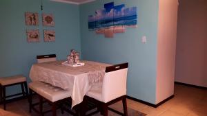 mesa de comedor con 2 sillas blancas y pared rosa en Fully Air-Conditioned Beach Front Penthouse Apartment en Naguabo