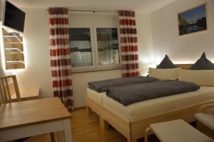 a bedroom with a bed and a table in it at Villa Müsli in Dettingen an der Iller