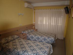 een kamer met 2 bedden en een raam bij Hostal San Jorge in Zaragoza