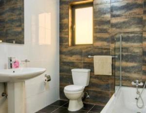 a bathroom with a toilet and a sink and a shower at Water's Edge Apartment in St. Paul's Bay +11 photos