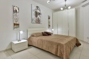 a bedroom with a bed in a white room at Water's Edge Apartment in St. Paul's Bay