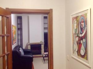 una sala de estar con una silla y una pintura en la pared en aerOPOrto Guesthouse, en Maia