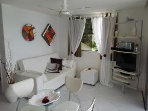 una sala de estar blanca con un sofá blanco y sillas en Habana Beach Flat, en Natal