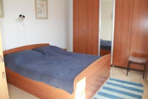 a bedroom with a bed with a blue blanket and a mirror at Apartman Anka in Viganj