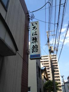 een bord aan de zijkant van een gebouw bij Iroha Ryokan in Aomori