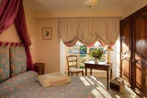 um quarto com uma cama, uma mesa e uma janela em Chateau Colbert em Maulévrier
