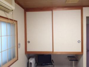 um par de armários numa cozinha com micro-ondas em Iroha Ryokan em Aomori