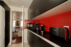 a kitchen with red walls and a black counter top at Duplex Lisbon Castle Sao Jorge in Lisbon +30 photos