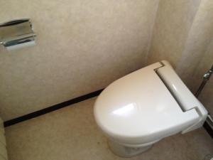 a white toilet sitting inside of a bathroom at Iroha Ryokan in Aomori