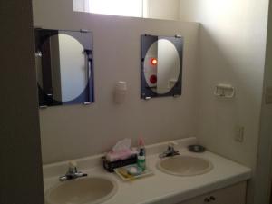 uma casa de banho com dois lavatórios e dois espelhos em Iroha Ryokan em Aomori