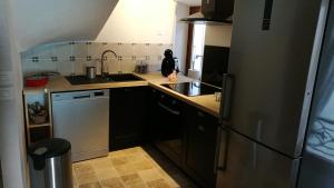 a kitchen with a sink and a refrigerator at La petite maison in Sisteron