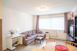 ein Wohnzimmer mit einem Sofa und einem Tisch in der Unterkunft Quality Stylish Flat in Russell Square in London