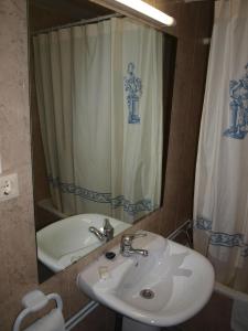 a bathroom with a sink and a shower curtain at Hostal San Jorge in Zaragoza