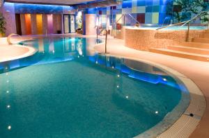 a swimming pool with blue water in a hotel at Spa Hotel Ciudad de Teruel in Teruel