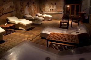 Cette chambre dispose de canapés, de tables et d'une baignoire. dans l'établissement Spa Hotel Ciudad de Teruel, à Teruel