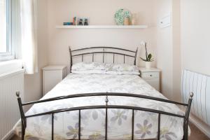 a bedroom with a bed with a white bedspread at Gwithian Holidays in Hayle