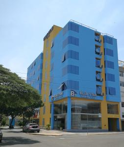 a blue and yellow building on a street at Blue Star Hotel in Lima