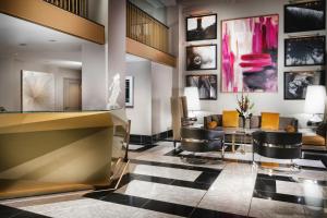 a lobby with a counter and stools and paintings at Staypineapple, An Elegant Hotel, Union Square in San Francisco