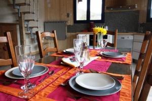 a dining room table with plates and glasses on it at Gîte de la Lombarde in Le Tholy