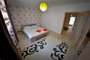 una piccola camera con letto e specchio di Terezianum Apartments, Free Parking a Sibiu