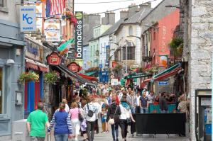a crowd of people walking down a busy city street at Skeffington Arms Hotel in Galway