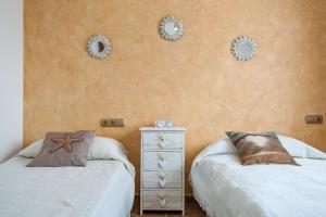 sypialnia z 2 łóżkami i 2 lustrami na ścianie w obiekcie Casa Pescadores de Vallterra w mieście El Palmar