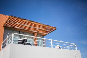a balcony on top of a building with a roof at Lomas del Real Aparthotel in Colonia del Sacramento