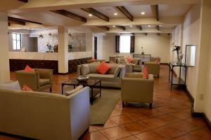 a living room filled with furniture and a large window at Hotel Agua Escondida in Taxco de Alarcón