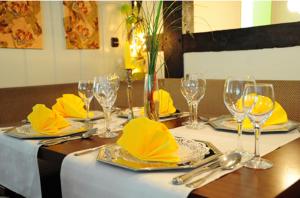 a table with yellow napkins and wine glasses on it at Hotel Schäferhof in Bückeburg