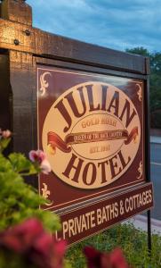 a sign for a hotel with flowers in the foreground at Julian Gold Rush Hotel in Julian