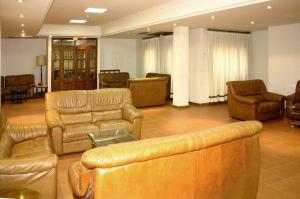 a large living room with leather couches and chairs at Hotel Hispanidad in Guadalupe