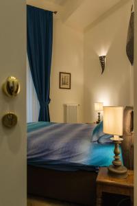 a bedroom with a bed with blue sheets and a lamp at B&B Univercity in Naples