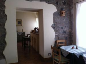 a dining room with a table and a stone wall at B&B Poggio Stallone in Orvieto
