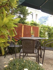 une table et des chaises assises sur une terrasse dans l'établissement Hotel Vier Jahreszeiten, à Bad Reichenhall